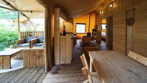 A wooden cabin interior with a dining area, kitchen, and a cozy seating area. - Holiday Home in Otterlo With Terrace (Otterlo)
