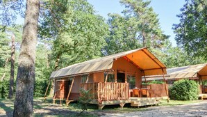 A rustic cabin with a wooden deck, surrounded by trees. - Holiday Home in Otterlo With Terrace (Otterlo)
