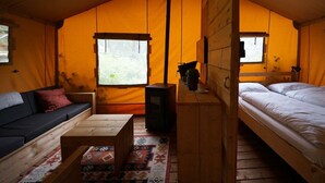 A cozy tent-style room with a sofa, a bed, a small table, and a fireplace. - Holiday Home in Otterlo With Terrace (Otterlo)