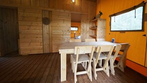 A wooden interior with a dining table and chairs, a window with a view, and a shelf with items. - Holiday Home in Otterlo With Terrace (Otterlo)