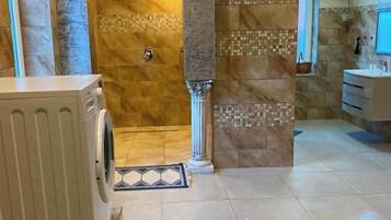Une salle de bain avec une douche, un lavabo et des toilettes.