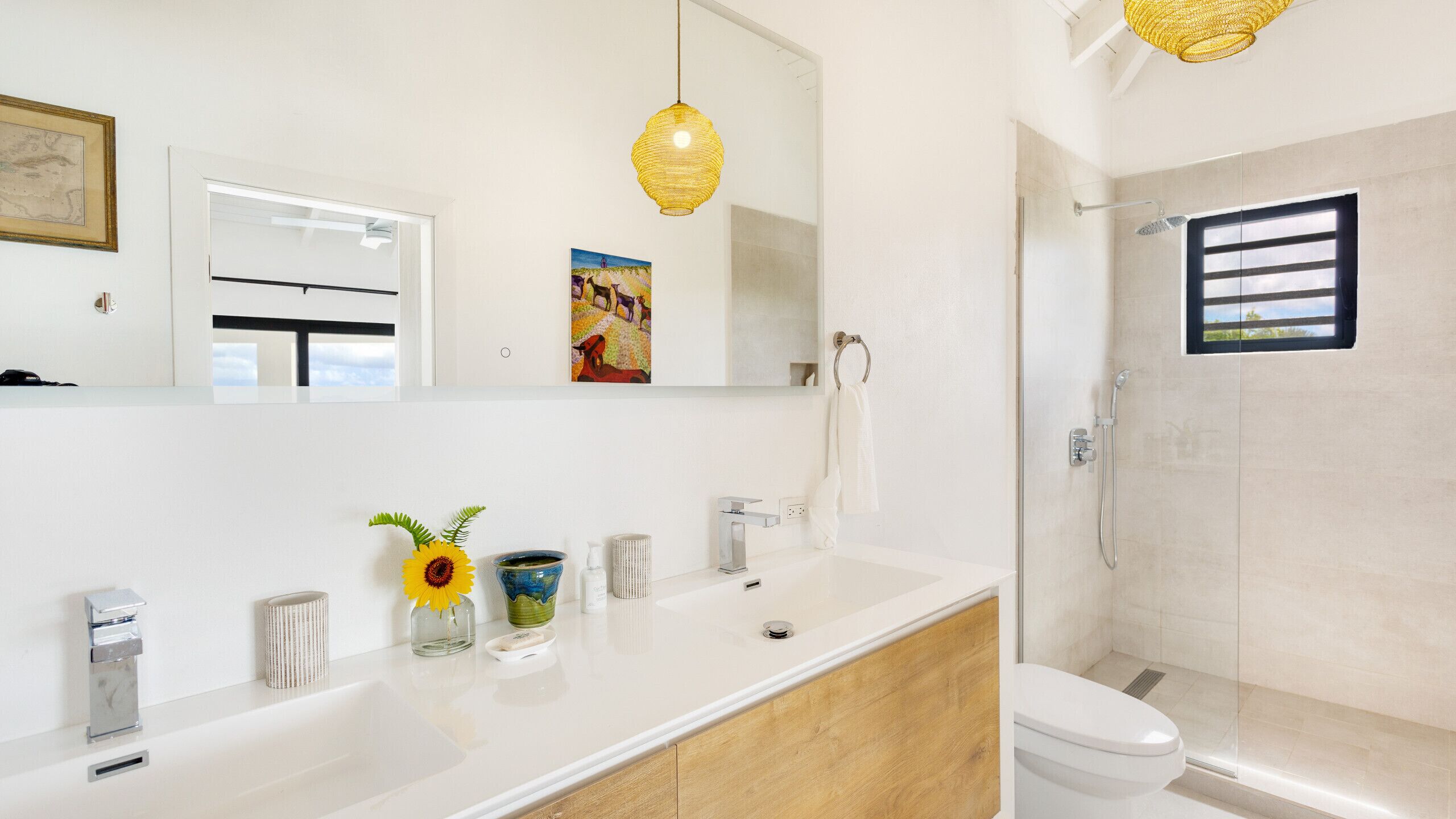 A modern bathroom with a white vanity, a glass shower enclosure, and a large mirror.