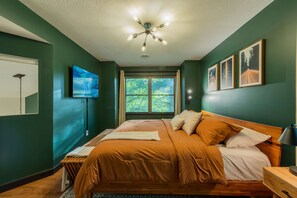 A bedroom with a bed, a ceiling fan, a window, and wall-mounted artwork. - Moonstone | Hocking Hills, Modern, Hot Tub (Rockbridge)