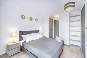 A bedroom with a bed, bedside tables, a wardrobe, and a ceiling light. - The Place Apartment 1BR and Wifi (Ñuñoa)