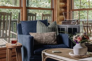 Ein gemütliches Zimmer mit blauem Sessel, einem kleinen Tisch mit einer Teetasse und einem Radio.