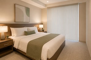 Ein Hotelzimmer mit einem Bett, zwei Nachttischen mit Lampen, einem kleinen Tischchen, einem großen Fenster mit Jalousien und einem an der Wand hängenden abstrakten Kunstwerk.