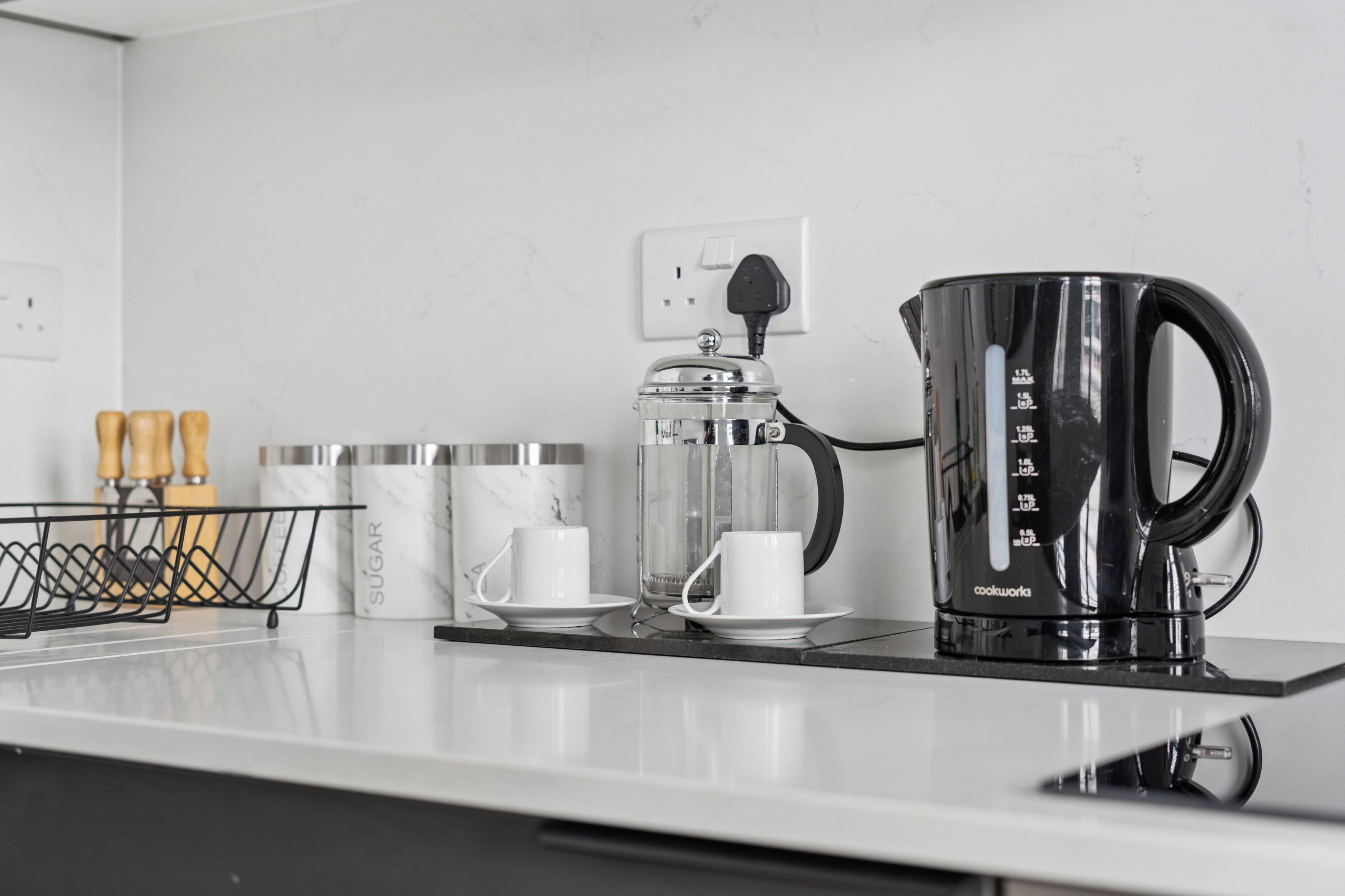 Un plan de travail de cuisine avec une machine à café, une balance et une cafetière.