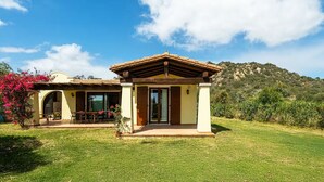 A house with a patio, a covered area, and a mountain in the background. - Villa Fiammetta, 500 meters from the beach (Castiadas)