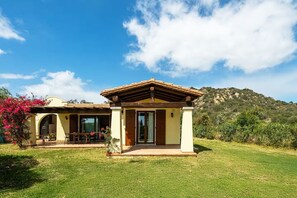 A house with a patio, a covered area, and a mountain in the background. - Villa Fiammetta, 500 meters from the beach (Castiadas)