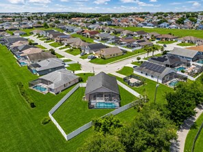 A residential area with houses, a central road, and a swimming pool. - Private 3BD2BA Dream Pool Escape Close To Parks (Davenport)