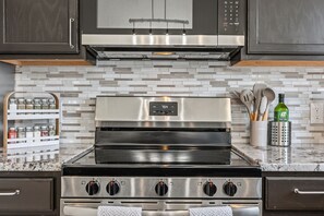 A kitchen with a stainless steel oven, a microwave, and a tiled backsplash. - Private 3BD2BA Dream Pool Escape Close To Parks (Davenport)