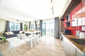 Eine moderne Wohnung mit Essbereich, Küche und einem Balkon mit Blick auf die Stadt.