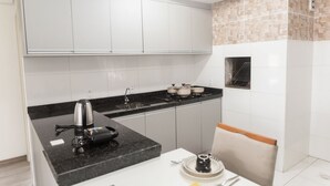 A modern kitchen with white cabinets, a black countertop, and a built-in oven.