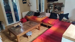 Uma sala de estar aconchegante com sofá, mesa de centro de madeira e televisão.