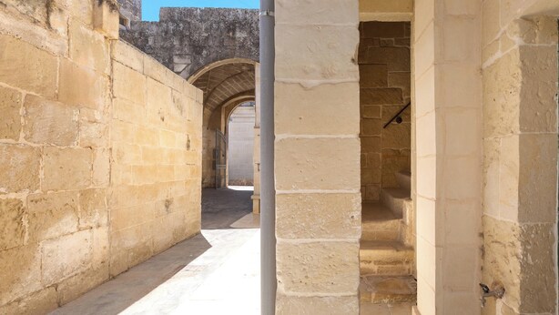 A narrow corridor with stone walls and an arched doorway. - L'Antica Corte - Camera Superior by BarbarHouse (Maglie)