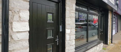A sandwich shop with a stone facade and a black door.