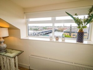 A room with a view of a bridge, a radiator, and a table with a lamp. - Suite 33B (Londonderry)