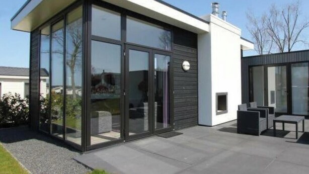 Un edificio moderno caratterizzato da ampie vetrate, un tetto piano e un design minimalista.