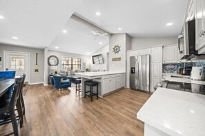 A modern kitchen with a central island, white cabinetry, and a stainless steel refrigerator. - Lakefront Retreat w/ Stunning Views | Hot Springs (Hot Springs)