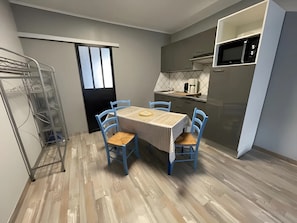 Eine kleine Küche mit einer Mikrowelle, einer Kaffeemaschine und einer Arbeitsplatte.