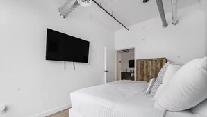 Ein Schlafzimmer mit einem Bett, einem Fernseher und einem Holzschrank.