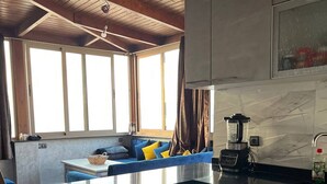Een moderne keuken met een centraal eiland, een ingebouwde wasmachine en een eethoek met blauwe meubels.