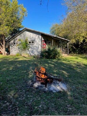 A house with a fire pit in the yard.