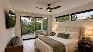 A modern bedroom with a large bed, a ceiling fan, a TV, and a city view. - New Build Downtown Views Pool Spa Walkable (Austin)