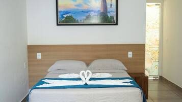 Ein Hotelzimmer mit einem Bett, einem Landschaftsbild und einem Fenster mit Ausblick.