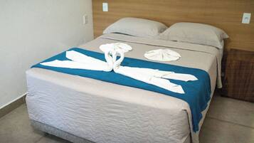 Ein Bett mit blauer Decke, weißen Handtüchern und einem hölzernen Kopfteil.