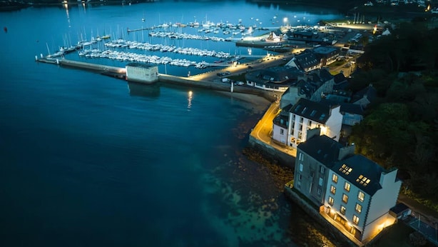 An aerial view of a marina with boats docked, a large building with multiple windows, and a waterfront promenade. - Luxury Duplex With Magnificent sea View (Landeda)