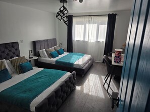 Habitación de hotel con dos camas, una mesita pequeña con un vaso de palomitas de maíz y una silla.