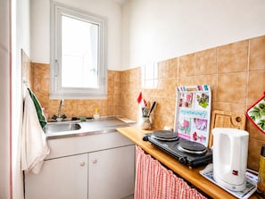 Eine Küche mit Fenster, Spüle, Kaffeemaschine und Schneidebrett.