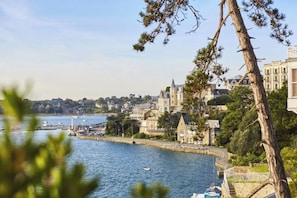 Eine Küstenstadt mit Uferpromenade, historischen Gebäuden und Blick aufs Meer.