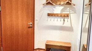 A room with a wooden door, a wooden bench, a coat rack, and a mirror. - Haus zum Alpenblick - Wannenhorn by Interhome (Bellwald)