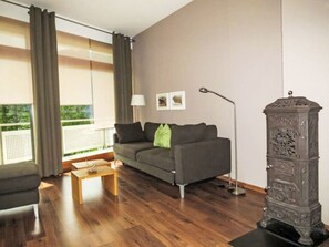 En moderne stue med sofa, sofabord, gulvlampe og et dekorativt skab.