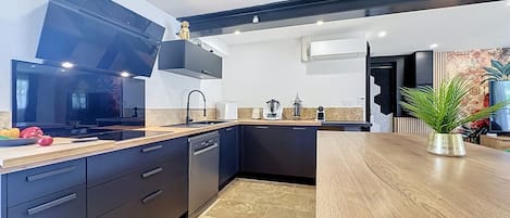 A modern kitchen with dark cabinetry, a wooden countertop, and a built-in oven.
