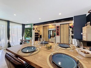 A modern dining area with a wooden table set for six, surrounded by chairs. - La Villa Soleya by Interhome (Rodilhan)