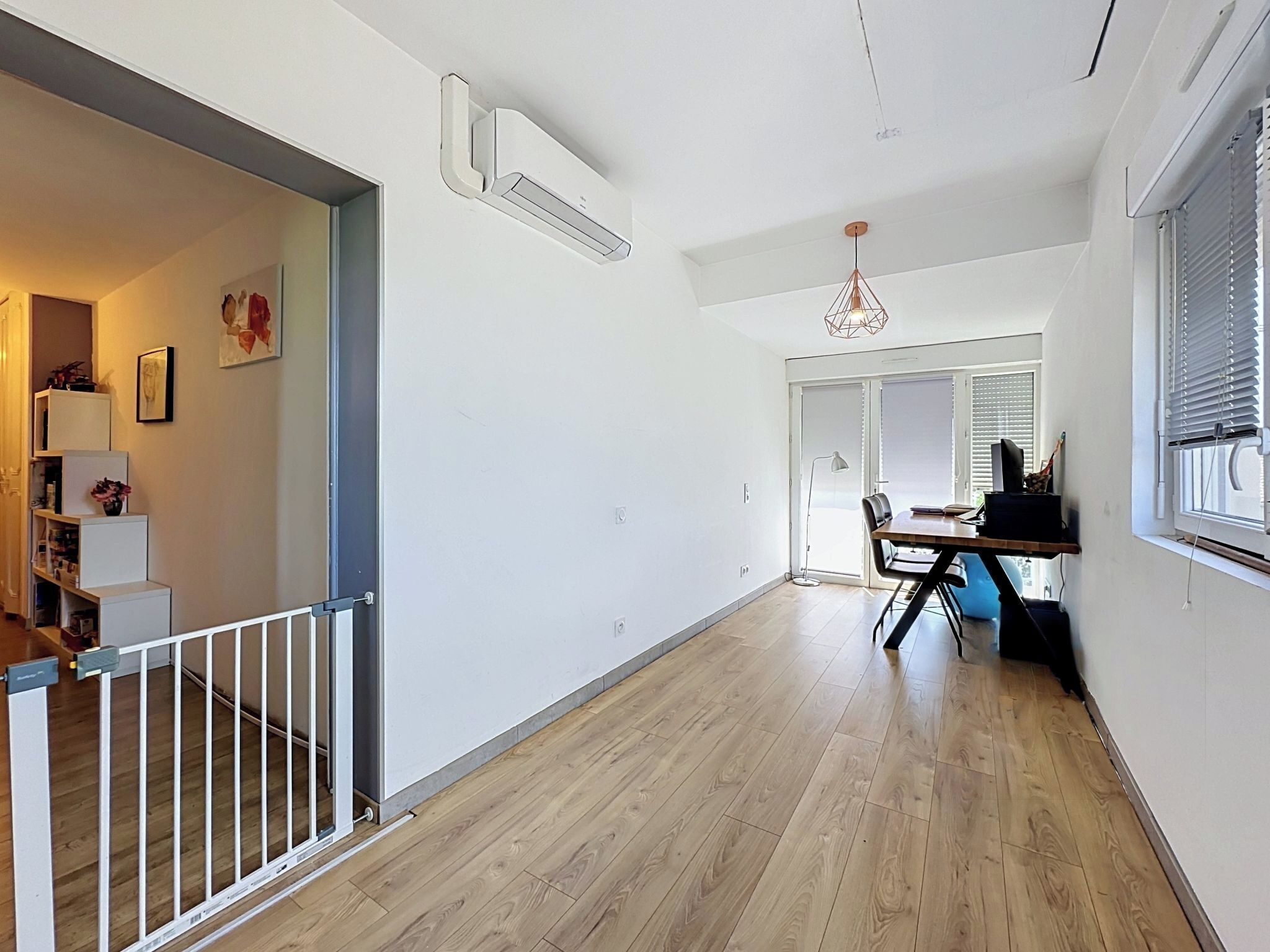 A modern interior with a staircase, a dining area, and a hallway.
