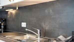 Eine moderne Küche mit Spüle aus Edelstahl, einem Armatur und einer Arbeitsplatte.