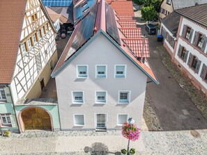 A multi-story building with a symmetrical facade, a central entrance with a large arched doorway, and a tiled roof. - Fiona (S6) by Interhome (Endingen am Kaiserstuhl)