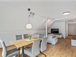 A modern living space with a dining area, seating, a TV, and a staircase. - Laura (S7) by Interhome (Endingen am Kaiserstuhl)