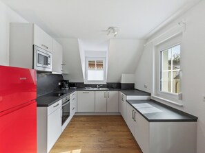 A modern kitchen with white cabinets, a red refrigerator, a microwave, and a coffee maker. - Laura (S7) by Interhome (Endingen am Kaiserstuhl)