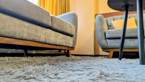 Un sofá y un sillón en una habitación con alfombra.