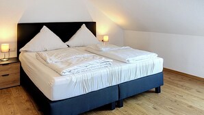 Ein Schlafzimmer mit einem Bett, Nachttischen und Lampen.