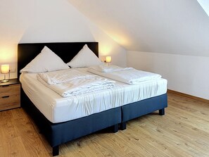 Ein Schlafzimmer mit einem Bett, Nachttischen und Lampen.