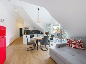 Ein modernes Loft-Apartment mit Essbereich, Küche und einem Balkon mit Blick.