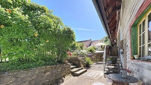 Un sendero de piedra que lleva a un edificio de madera con un pequeño espacio de estar al aire libre.