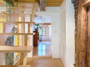 Eine Holztreppe führt zu einem Raum mit Blick auf einen Garten.