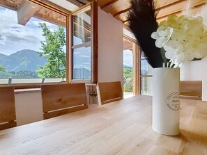 Ein Holztisch mit einer weißen Vase, gefüllt mit weißen Blumen und schwarzen Federn.